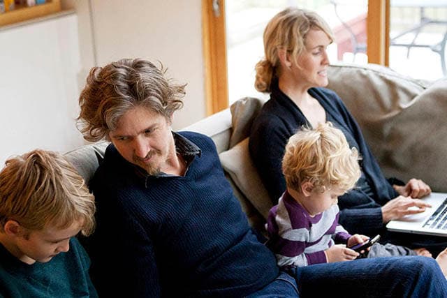 Familie sidder og hygger i sin sofa