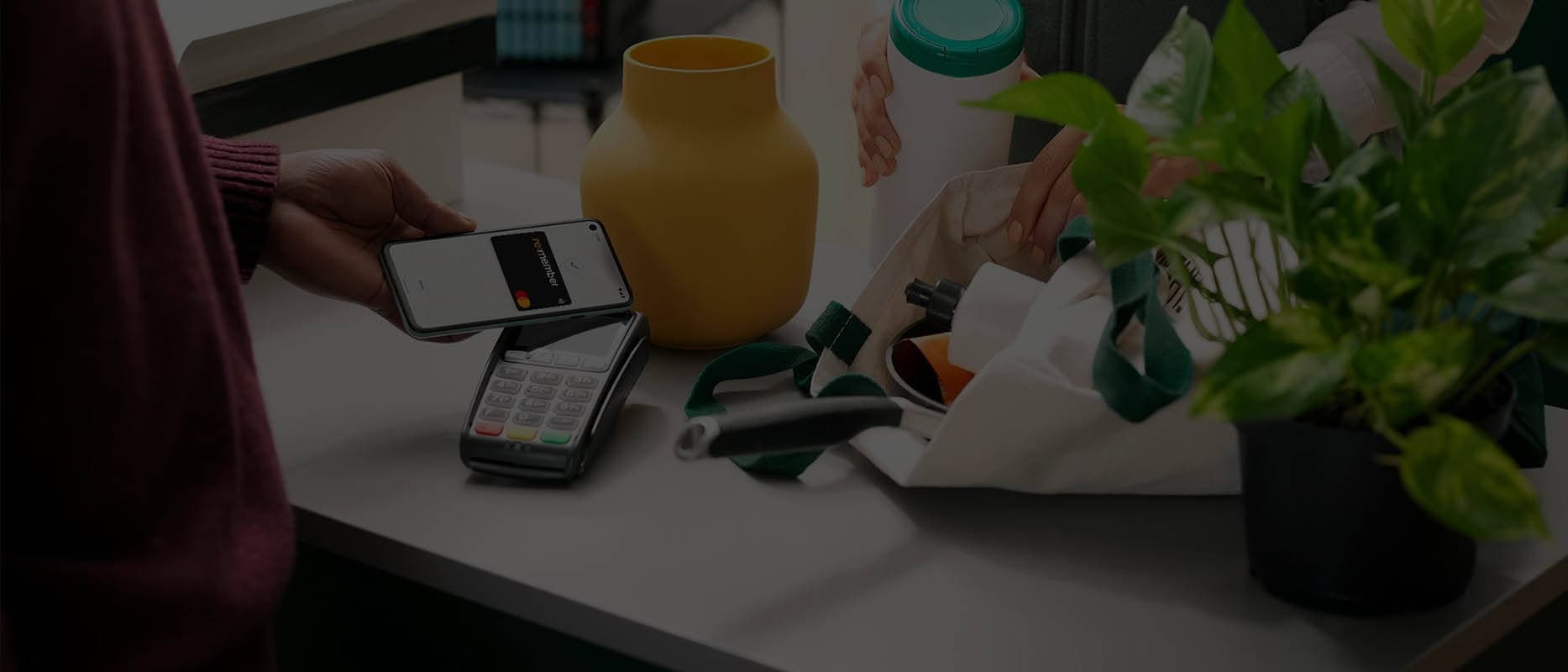 Kvinde betaler med mobilen i butikken.